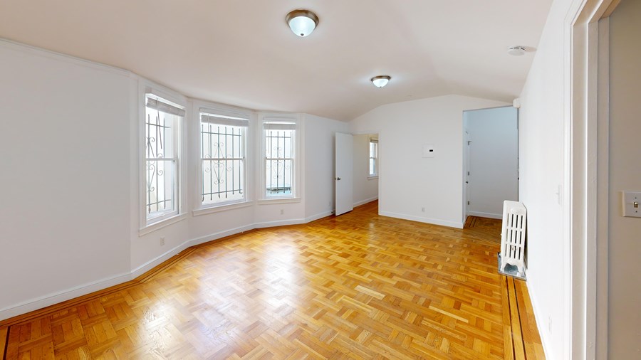 A room with wooden flooring and white walls.